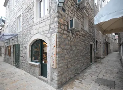 a stone building with a store on a street at Sea Paradise Apartment in Budva