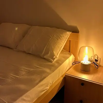 a bed with a lamp on a wooden night stand at Villa Vistamar Lapcici in Budva