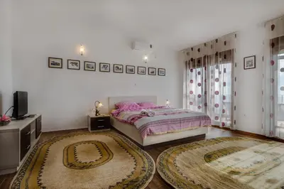 a bedroom with a bed and two rugs at Villa Ladera Lapcici in Budva