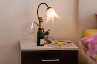 a bottle of champagne and a wine glass on a night stand at Villa Ladera Lapcici in Budva