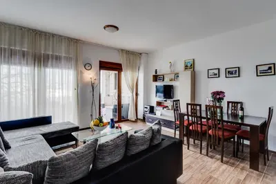 a living room with a black couch and a table at Villa Ladera Lapcici in Budva