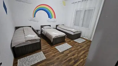 a room with two beds and a rainbow on the wall at Guest house Boljević in Rap