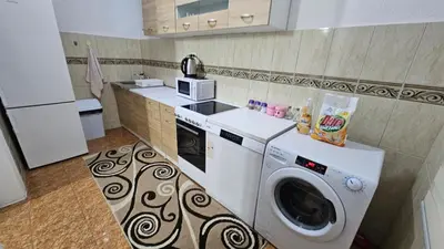 a kitchen with a washing machine and a microwave at Guest house Boljević in Rap