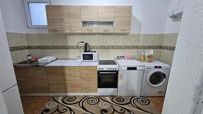 a kitchen with a washing machine and a microwave at Guest house Boljević in Rap