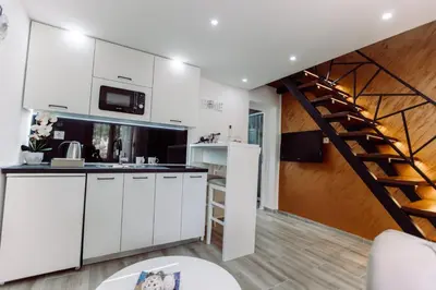 a kitchen with white cabinets and a staircase at Aria in Cetinje