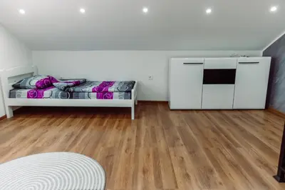 a white room with a bed and a wooden floor at Aria in Cetinje
