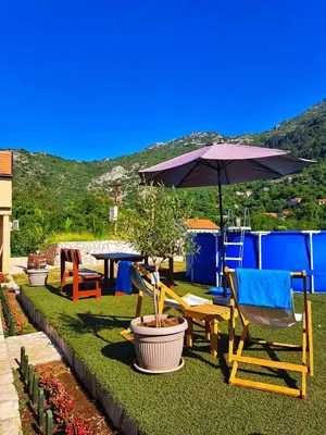 a patio with chairs and an umbrella and a table at Aria in Cetinje