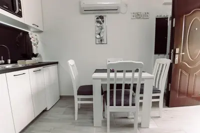a white kitchen with a white table and chairs at Aria in Cetinje