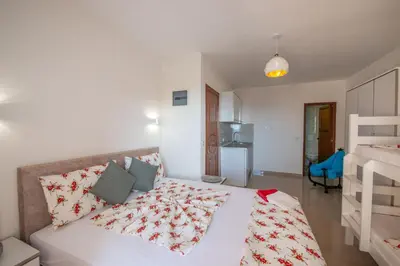 a bedroom with a bed with a red and white comforter at M&M Apartments in Utjeha