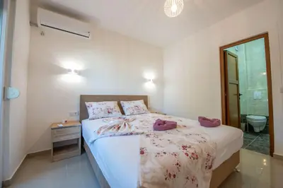 a bedroom with a bed with purple shoes on it at M&M Apartments in Utjeha