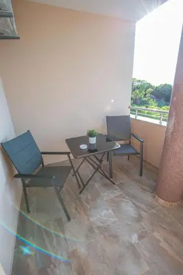 two chairs and a table in a room with a balcony at M&M Apartments in Utjeha