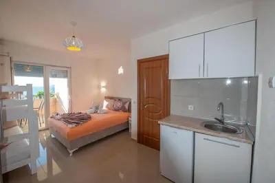 a kitchen with a bed and a sink in a room at M&M Apartments in Utjeha
