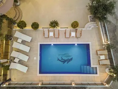 a swimming pool in a building with a diver in the water at Villa Lux Rajović in Budva