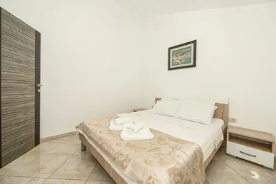 a bedroom with a large bed with white sheets at Villa Lux Rajović in Budva