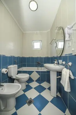 a blue and white bathroom with two toilets and a sink at Villa Lux Rajović in Budva