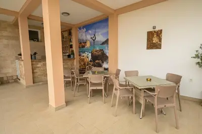 a dining room with tables and chairs and a painting at Villa Lux Rajović in Budva