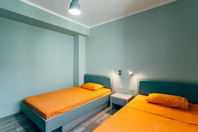 two beds in a room with blue and orange at Budva Gate Penthouse in Budva