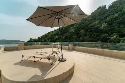 a picnic table with an umbrella on a patio at Budva Gate Penthouse in Budva
