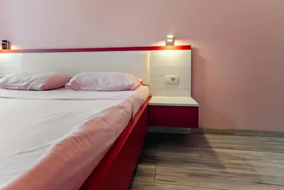 a bedroom with a bed with a red headboard at Budva Gate Penthouse in Budva