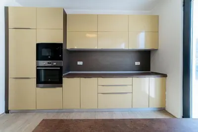 a kitchen with white cabinets and a black appliance at Budva Gate Penthouse in Budva