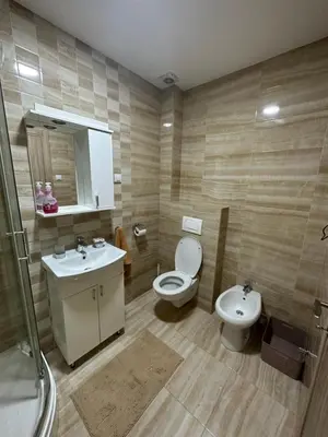 a bathroom with a toilet and a sink and a mirror at Kropa apartman in Podgorica