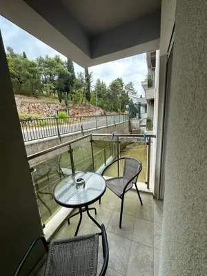 a balcony with a table and chairs and a window at Kropa apartman in Podgorica