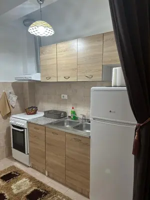a kitchen with a white refrigerator and a sink at Kropa apartman in Podgorica