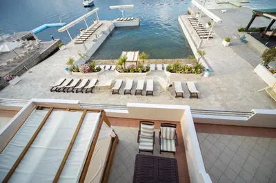 a view of a pool with chairs and the water at Apartments Adeona in Tivat