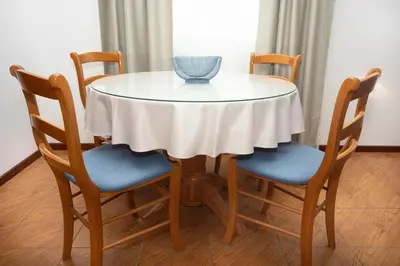 a table with four chairs and a blue vase on it at Apartments Adeona in Tivat