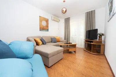 a living room with a couch and a tv at Apartments Adeona in Tivat