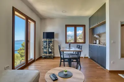 a kitchen and living room with a table and chairs at Vila Aria vista in Petrovac na Moru