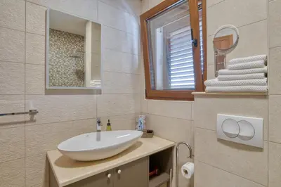 a bathroom with a sink and a mirror and towels at Vila Aria vista in Petrovac na Moru