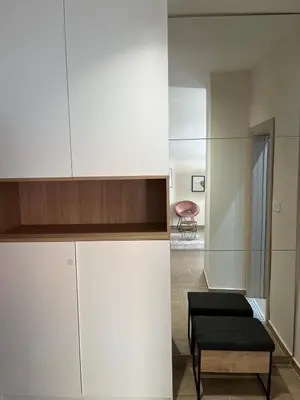 a kitchen with white cabinets and a stool in a room at Apartment Quince in Budva