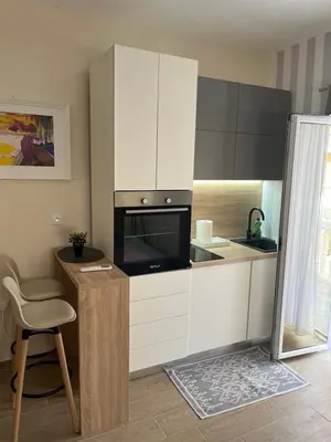 a kitchen with white cabinets and a counter with a microwave at Apartment Quince in Budva