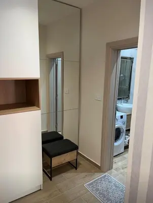 a room with a mirror and a bench in a bathroom at Apartment Quince in Budva