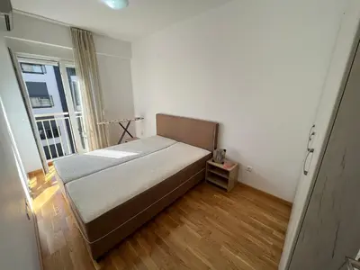 a small bedroom with a bed and a window at Golden parrot in Podgorica