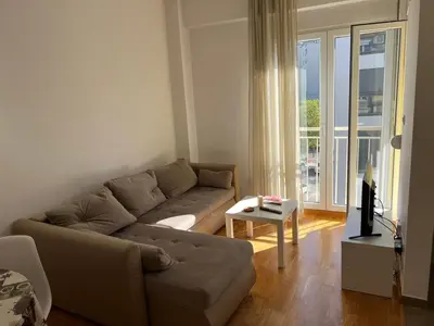 a living room with a couch and a large window at Golden parrot in Podgorica