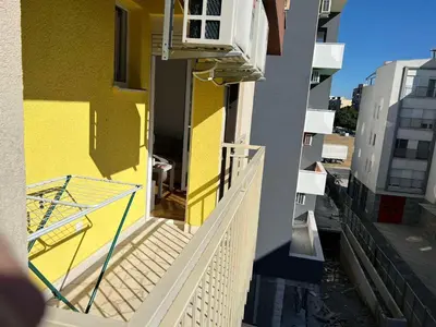 a balcony of a yellow building with a white railing at Golden parrot in Podgorica