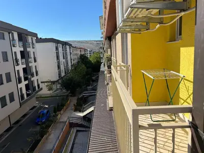 a balcony of a yellow building with a view of a street at Golden parrot in Podgorica