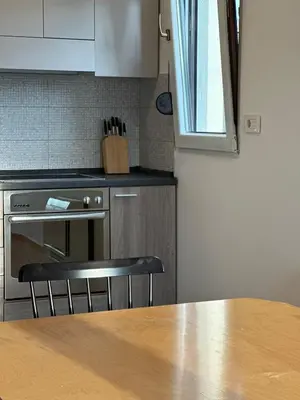 a kitchen with a wooden table and a counter top at City Oasis - two bedroom apartment in Blok 5 in Podgorica