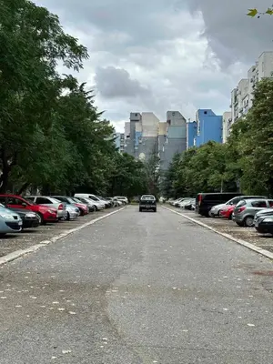 a car is driving down a street with parked cars at City Oasis - two bedroom apartment in Blok 5 in Podgorica