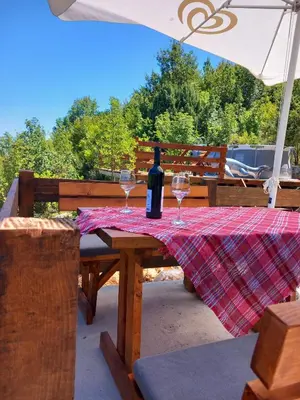 a picnic table with wine glasses and an umbrella at LAKE VIEW PREVLAKA in Cetinje