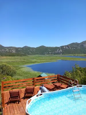 a swimming pool with chairs and a view of a lake at LAKE VIEW PREVLAKA in Cetinje