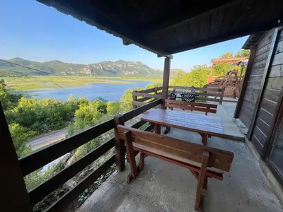 two benches on a porch with a view of a lake at LAKE VIEW PREVLAKA in Cetinje
