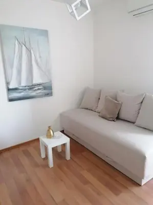 a living room with a white couch and a table at Smile in Becici