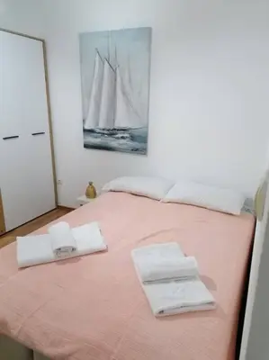 a bedroom with a pink bed with towels on it at Smile in Becici