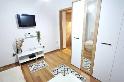 a living room with a mirror and a tv at Smile in Becici