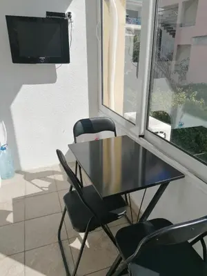 a black table and chairs in a room with a tv at Smile in Becici