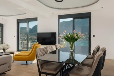 a dining room with a glass table and chairs at Berge Apartments in Kotor