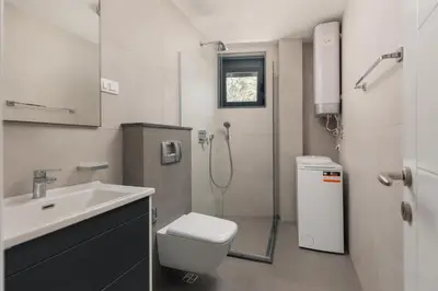 a bathroom with a shower and a toilet and a sink at Berge Apartments in Kotor